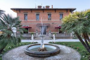 a fountain in front of a building with palm trees at The Rif - Boutique Hotel in Pisa