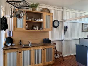 a kitchen with a sink and a clock on the wall at Evanston Station in Ilfracombe