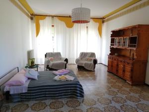 ein Schlafzimmer mit einem Bett und Stühlen in einem Zimmer in der Unterkunft Villetta di Campagna in Venturina Terme
