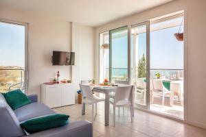 a living room with a table and chairs and a balcony at Residence Sunrise in Cesenatico