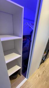 un armario con estanterías blancas en una habitación en Bienvenue chez vous "appartement classé 2 étoiles en RDC avec espace extérieur et parking", en Dole
