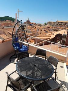 a table and chairs on a balcony with a swing at Holiday Home Mila in Dubrovnik