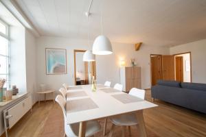 ein Esszimmer und ein Wohnzimmer mit einem weißen Tisch und Stühlen in der Unterkunft Exclusive 2 Bedroom Apartment in Sønderborg