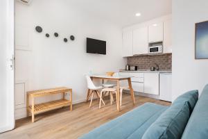 uma sala de estar com uma mesa e uma cozinha em RG Studio em Faro