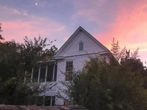 a white house with a sunset in the sky at Yerba at Bastrop in Bastrop