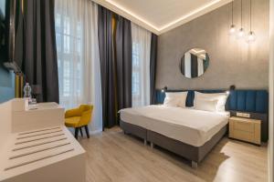 um quarto de hotel com uma cama e um espelho em Alta Moda Fashion Hotel em Budapeste