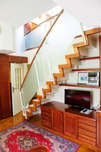 ein Wohnzimmer mit einer Treppe und einem TV in der Unterkunft Apartments SOELEK - Vila Golf in Rogaška Slatina