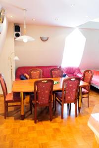 ein Esszimmer mit einem Tisch, Stühlen und einem Sofa in der Unterkunft Apartments SOELEK - Vila Golf in Rogaška Slatina