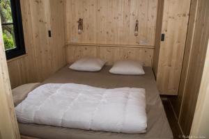 a bedroom with two beds in a wooden room at Camping Le Mouliat in Moncrabeau