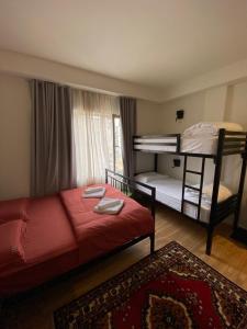 een slaapkamer met 2 stapelbedden en een rood bed bij Vanilla Sky Boutique Hostel in Tirana
