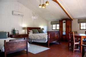克拉倫斯的住宿－Stonehaven Clarens，卧室配有一张床和一张桌子及椅子