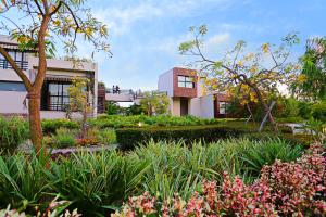 a garden in front of a building with flowers at The Golden Tusk By Ivory Destinations in Rāmnagar