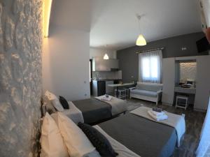 a bedroom with two beds and a living room at Vista Verde Apartments in Sidari