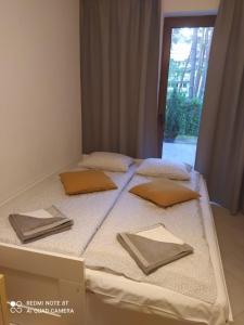 a bed in a box with four pillows on it at Apartament Rodzinny Baltic Park Stegna in Stegna