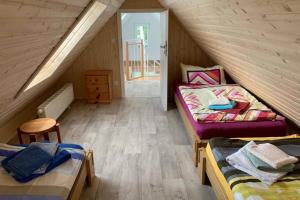 a attic room with two beds and a wooden floor at Ferienhaus im Igelbau in Baabe