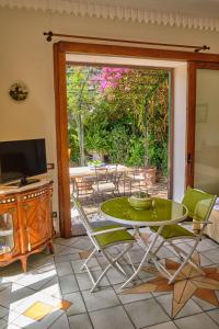 a room with a table and chairs and a sliding glass door at Villa Santa Sofia in Vico Equense