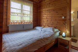 sypialnia z łóżkiem z drewnianą ścianą w obiekcie Cabana Dopca w mieście Racoşu de Jos