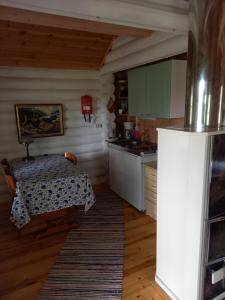 a kitchen with a table and a table and a refrigerator at Ellu in Kangasniemi