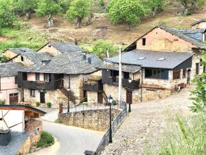 eine Gruppe von Steingebäuden mit einer Straße davor in der Unterkunft Hotel Rural El Lagar De Las Médulas in Orellán