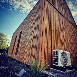 a wooden building with a fan next to a wall at Włókna Inn in Włókna