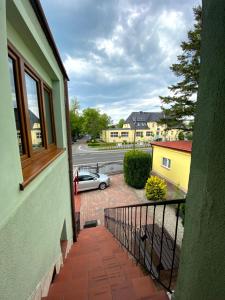 Un balcón de una casa con un coche en una calle en Zefir Pokoje, en Unieście