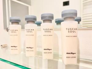 un grupo de botellas sentadas en una estantería de cristal en Palace Fontana Di Trevi Prestige, en Roma