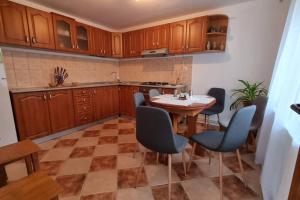 una cucina con mobili in legno, tavolo e sedie di Cervo Mountain House a Nehoiu