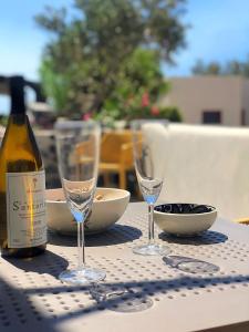 a table with two glasses and a bottle of wine at Thera Incognita Studios in Perissa