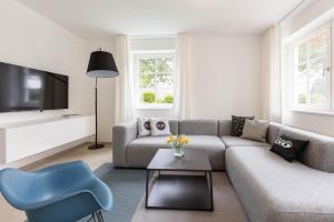 a living room with a couch and a blue chair at Pur A4 in Wustrow