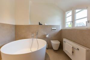 a bathroom with a white tub and a toilet at Pur A4 in Wustrow +37 photos