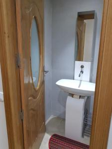 a bathroom with a sink and a wooden door at appartement en pleine centre gueliz en face théâtre royal in Marrakesh