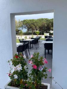 eine Terrasse mit Tischen, Stühlen und Blumen in der Unterkunft Hotel Mas des Lys in Saintes-Maries-de-la-Mer