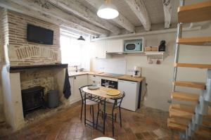 una pequeña cocina con mesa y chimenea en Le logis des Remparts, au coeur de Sancerre en Sancerre