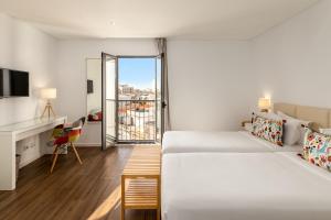 奥良Hotel Cidade de Olhão的有两张床和一个阳台的酒店房间