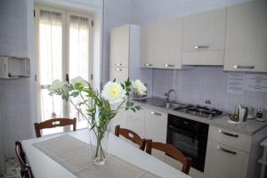 una cocina con una mesa con un jarrón de flores. en Calabrese Family en Pompeya