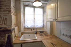 a kitchen with a sink and a window at Le logis des Remparts, au coeur de Sancerre in Sancerre