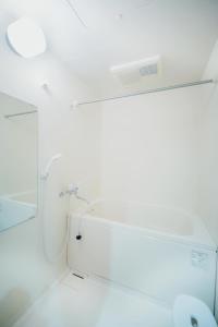 a white bathroom with a mirror and a sink at Kumamoto - Apartment / Vacation STAY 81139 in Kumamoto