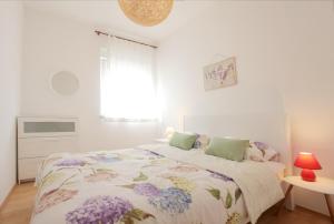 Un dormitorio blanco con una cama con flores. en Apartment Maria, en Medulin