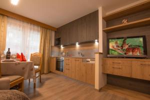 a kitchen with a flat screen tv on a wall at Residence Villa Artic in Campitello di Fassa