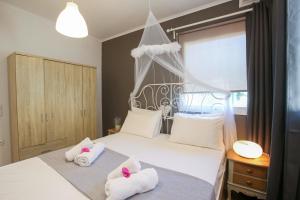 ein Schlafzimmer mit einem weißen Bett und Handtüchern darauf in der Unterkunft STAVROS HOUSE in Ýpsos