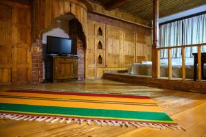 Guest Houses "Zlatna Oresha - Complex" في زيرافنا: غرفة معيشة مع سجادة ملونة على الأرض