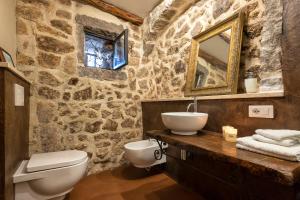 bagno in pietra con servizi igienici e lavandino di Esclusiva Dimora Storica nel cuore del Borgo Medievale---- Exclusive Historical House inside the Medieval Village a Castelsardo