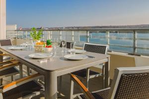 - une table sur un balcon avec vue sur l'eau dans l'établissement Dat Penthus, à Heiligenhafen