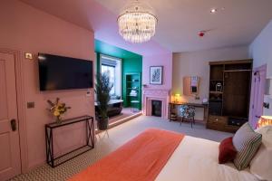 1 dormitorio con cama, TV y chimenea en Ingleside House en Cirencester