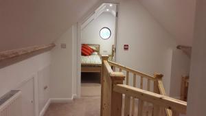 a staircase leading to a bedroom with a bed at Courtbrook Farm Apartments in Exeter