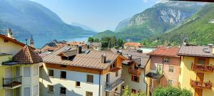 Blick auf eine Stadt mit Bergen und einem Wasserkörper in der Unterkunft Hotel Paganella in Molveno