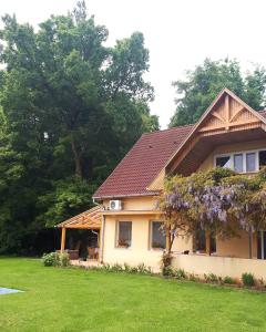 een huis met een boom met paarse bloemen erop bij Tündérkert in Nyírbátor