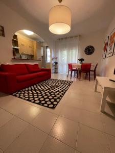 een woonkamer met een rode bank en een tafel bij La casetta di Sasà intero appartamento in Pescara