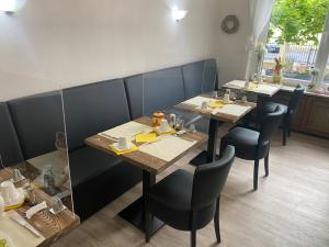 een eetkamer met tafels en stoelen in een restaurant bij Pension Auszeit in Bad Neuenahr-Ahrweiler
