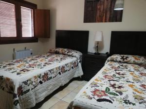 a bedroom with two beds and a table with a lamp at Casa Rural Del Antiguo Hojalatero in Ibdes